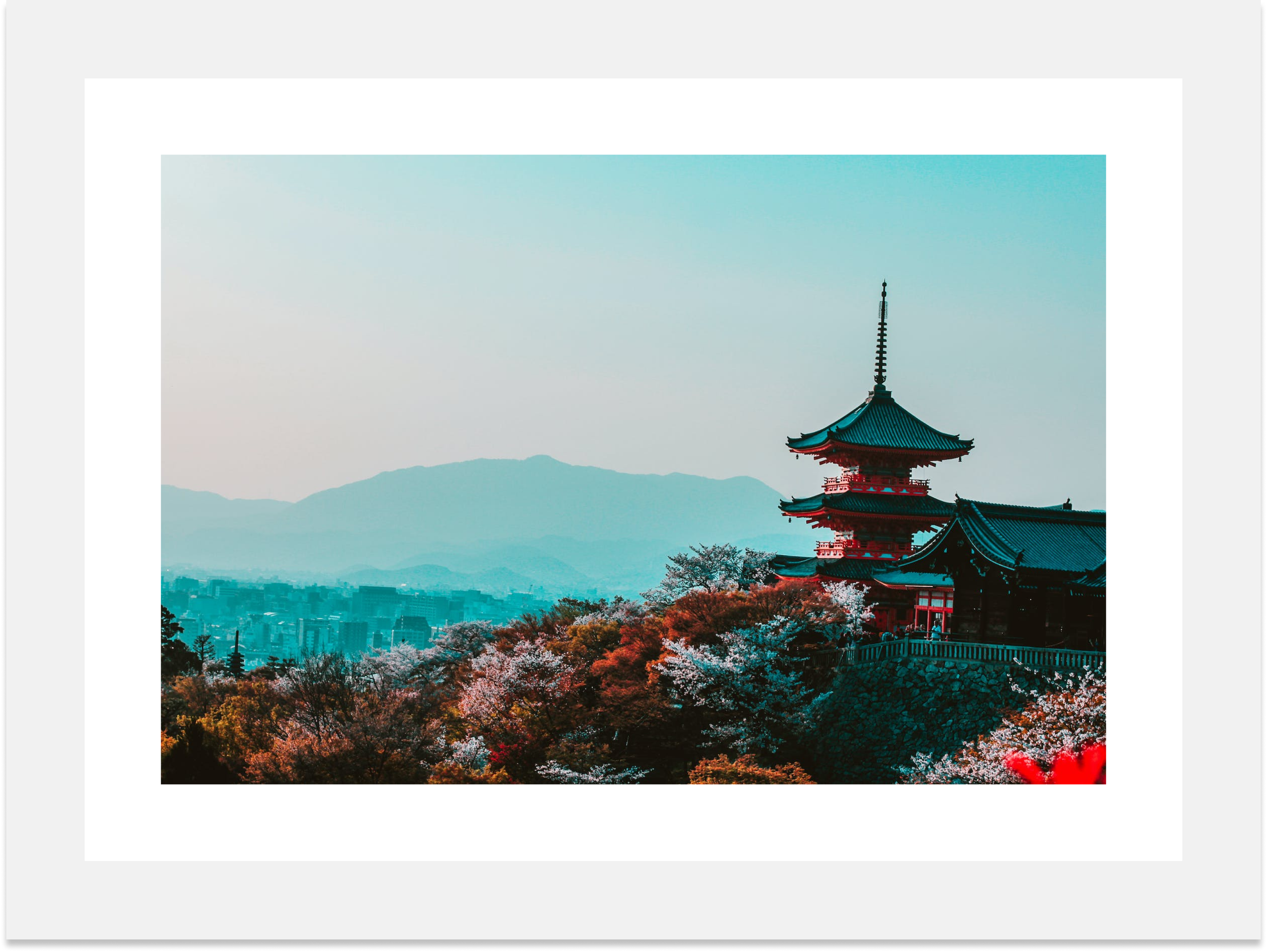 A red pagoda with a golden roof that stands atop a hill. The pagoda has five stories and it is topped with a spire. The pagoda is surrounded by trees, and a range of mountains can be seen in the background. The trees around the pagoda are mainly pines and maples. The mountains in the background are covered with greenery. The sky is clear and blue, and there are a few white clouds.