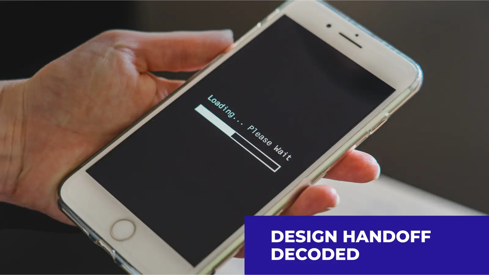 An individual is holding a smartphone, displaying a loading screen with the message "Loading... Please Wait." In the lower right corner, text in white on a blue background reads, "Design handoff decoded."